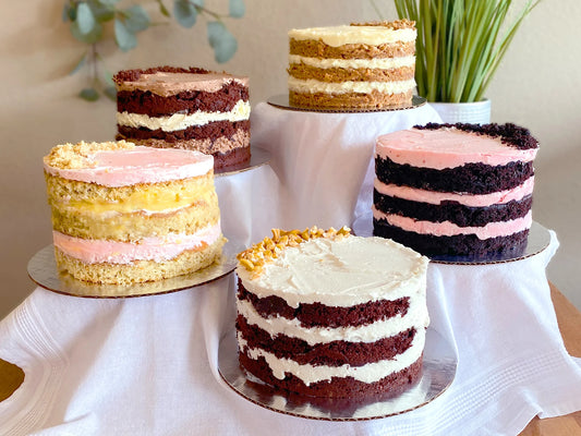 Photo of  a group of 5 layer cakes showing how they are 3 layers each of cake and frosting, with an arc of decorative crumb on the top.